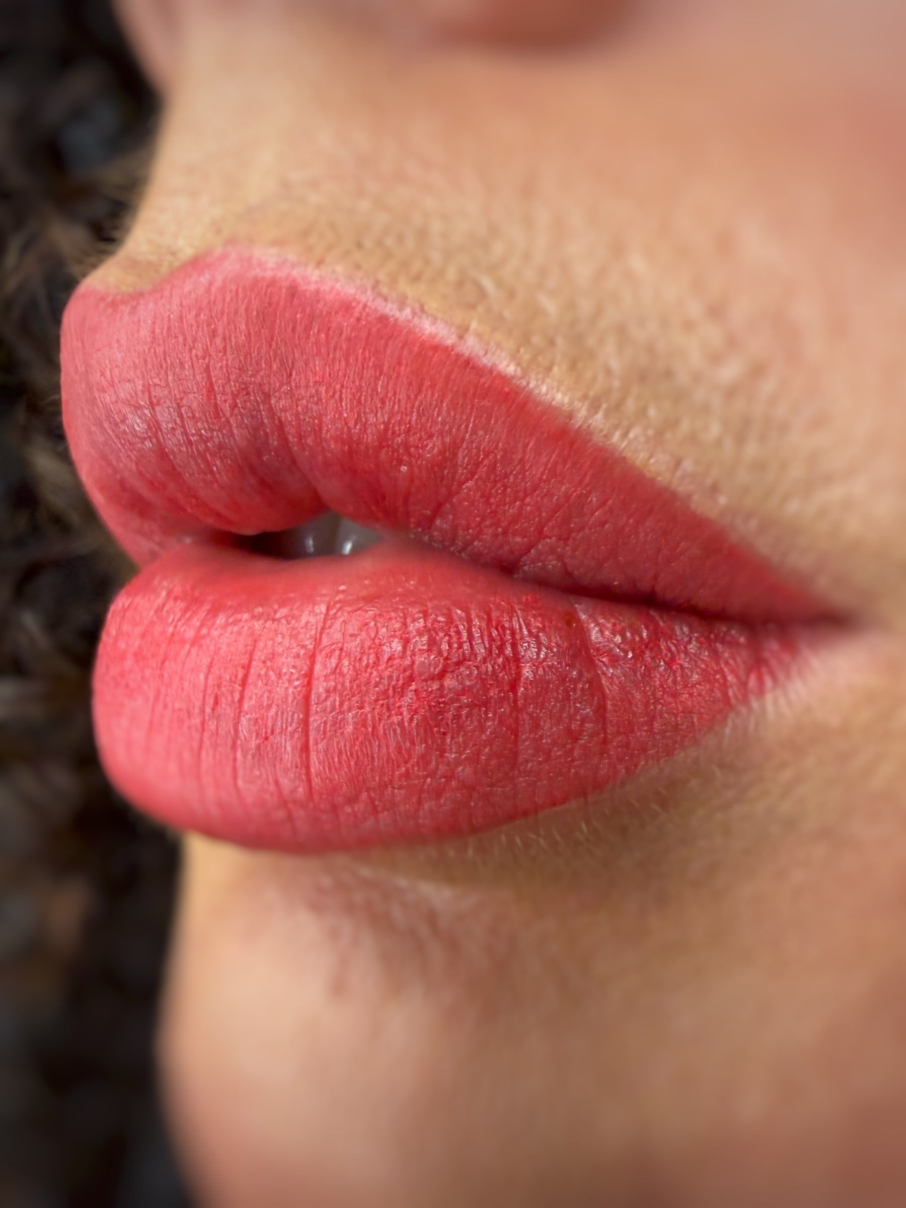 Labbra con dermopigmentazione dal colore corallo acceso, di profilo